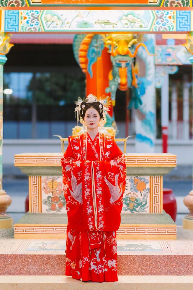 Frau Kleid China Neu Jahr. Porträt von ein Frau. Person im traditionell Kostüm. Frau im traditionell Kostüm. schön jung Frau im ein hell rot Kleid und ein Krone von Chinesisch Königin posieren. foto