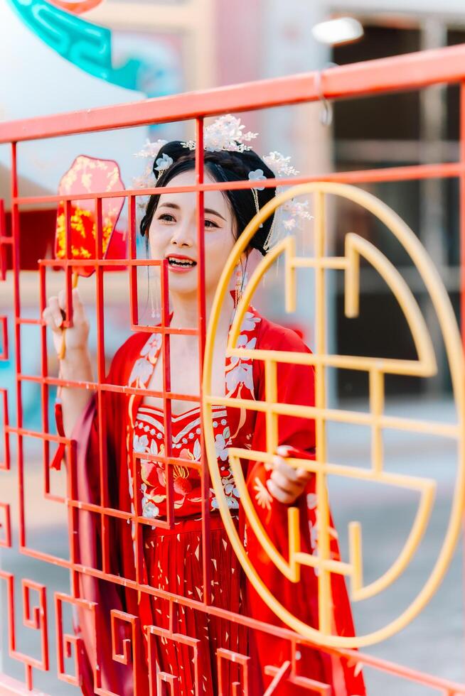 Frau Kleid China Neu Jahr. Porträt von ein Frau. Person im traditionell Kostüm. Frau im traditionell Kostüm. schön jung Frau im ein hell rot Kleid und ein Krone von Chinesisch Königin posieren. foto