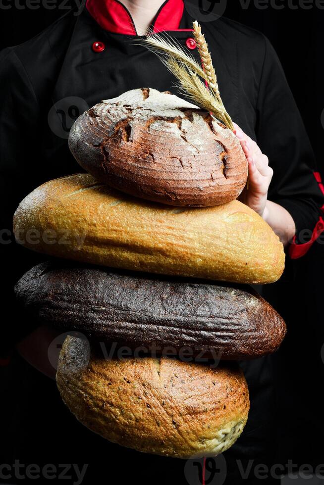 Hintergrund von Brot und Gebäck. ein Sortiment von Brot im das Hände von ein weiblich Bäcker. oben Sicht. foto