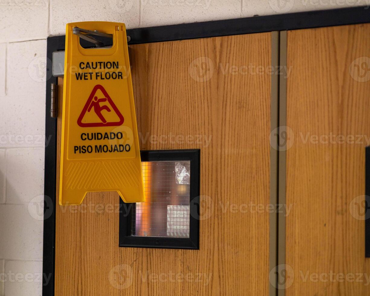 ein Sicherheit Fußboden Zeichen hängend auf ein Tür zum etwas Grund foto