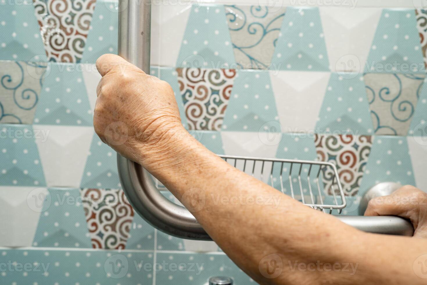 asiatisch Alten Frau verwenden Badezimmer Griff Sicherheit im Toilette, gesund stark medizinisch Konzept. foto