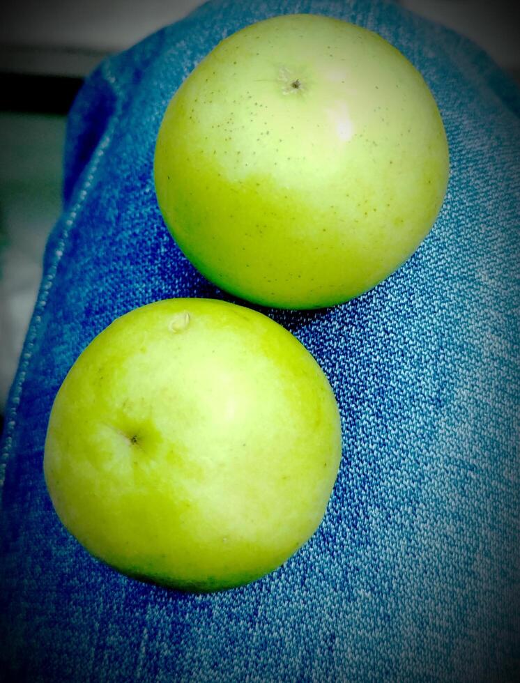 zwei Grün Äpfel sitzen auf ein hölzern Regal foto