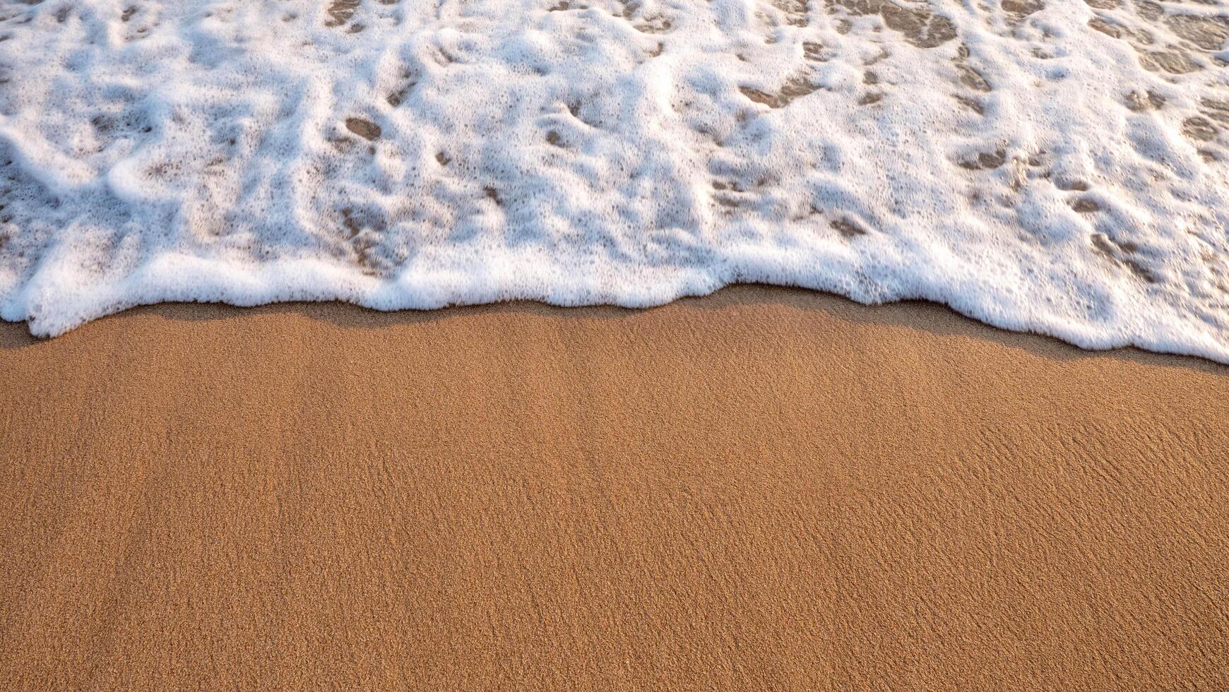 Weiß schaumig Hintergrund von Wellen abstürzen auf ein sandig Strand. foto