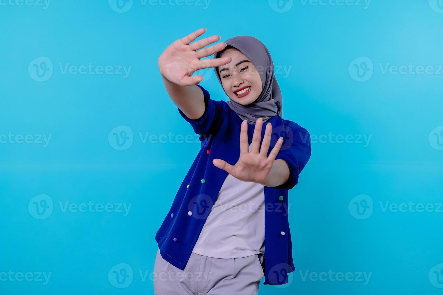 Optimistische charmante attraktive junge Frau mit süßem Lächeln freudig mit schönem weißem Lächeln auf hellblauem Hintergrund foto