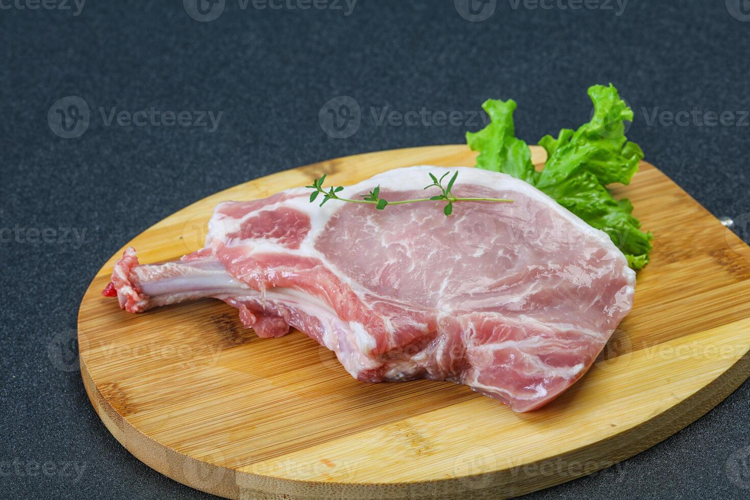 rohes schweineknochensteak über holz foto