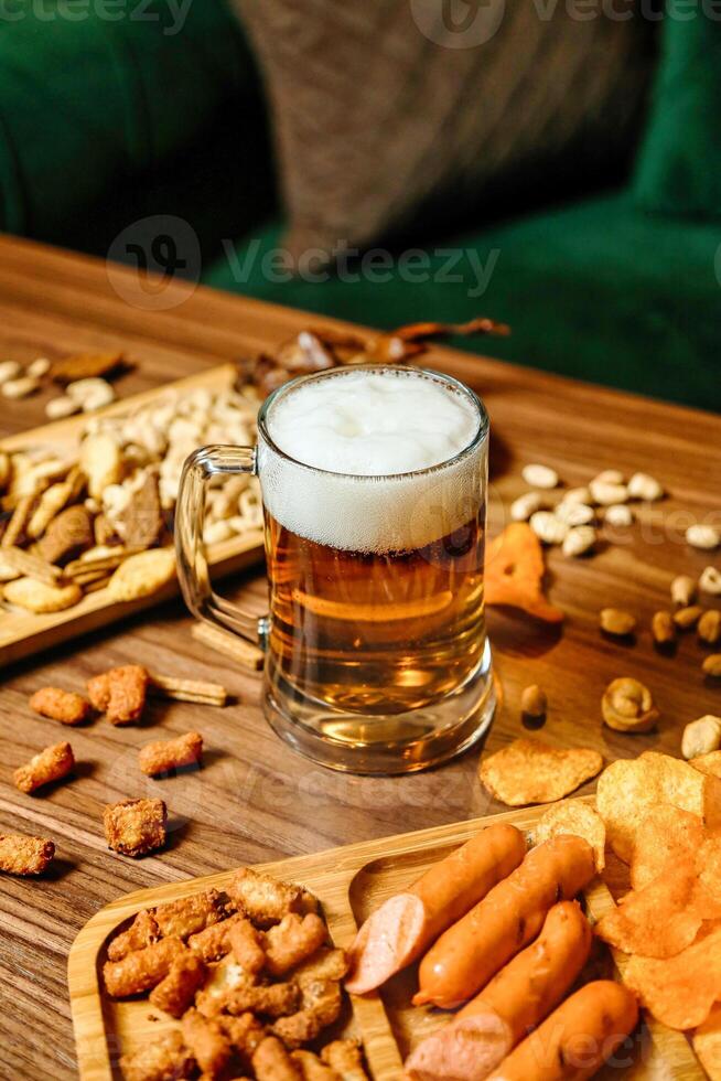 reichlich hölzern Tabelle mit sortiert Essen und Bier Becher foto