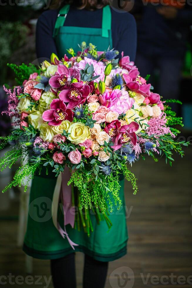 Frau im Grün Kleid halten Strauß von Blumen foto