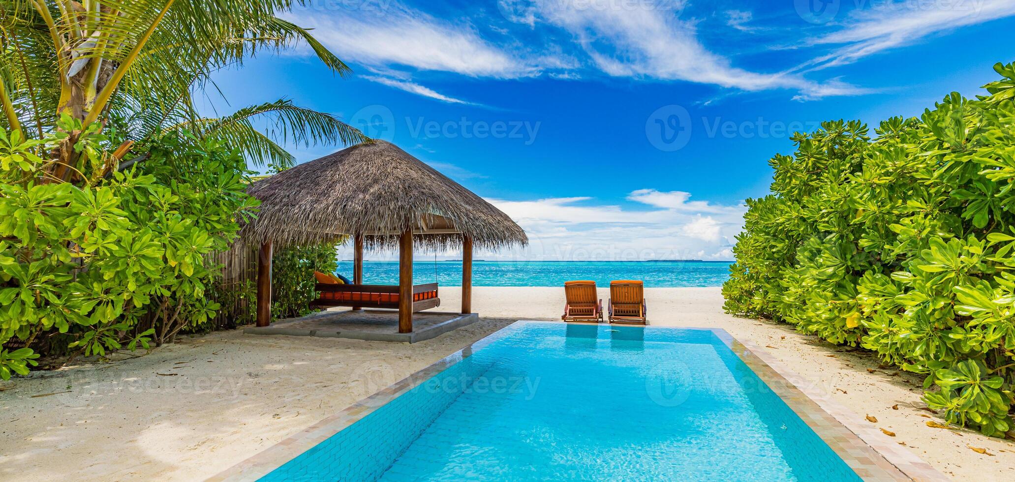 tropisch entspannen, draussen Tourismus Landschaft. Luxus Strand Resort mit Privat Schwimmen Schwimmbad und Strand Stühle oder Liegen unter Regenschirme Palme Bäume, sonnig Blau Himmel. Sommer- Reise und Ferien Hintergrund foto