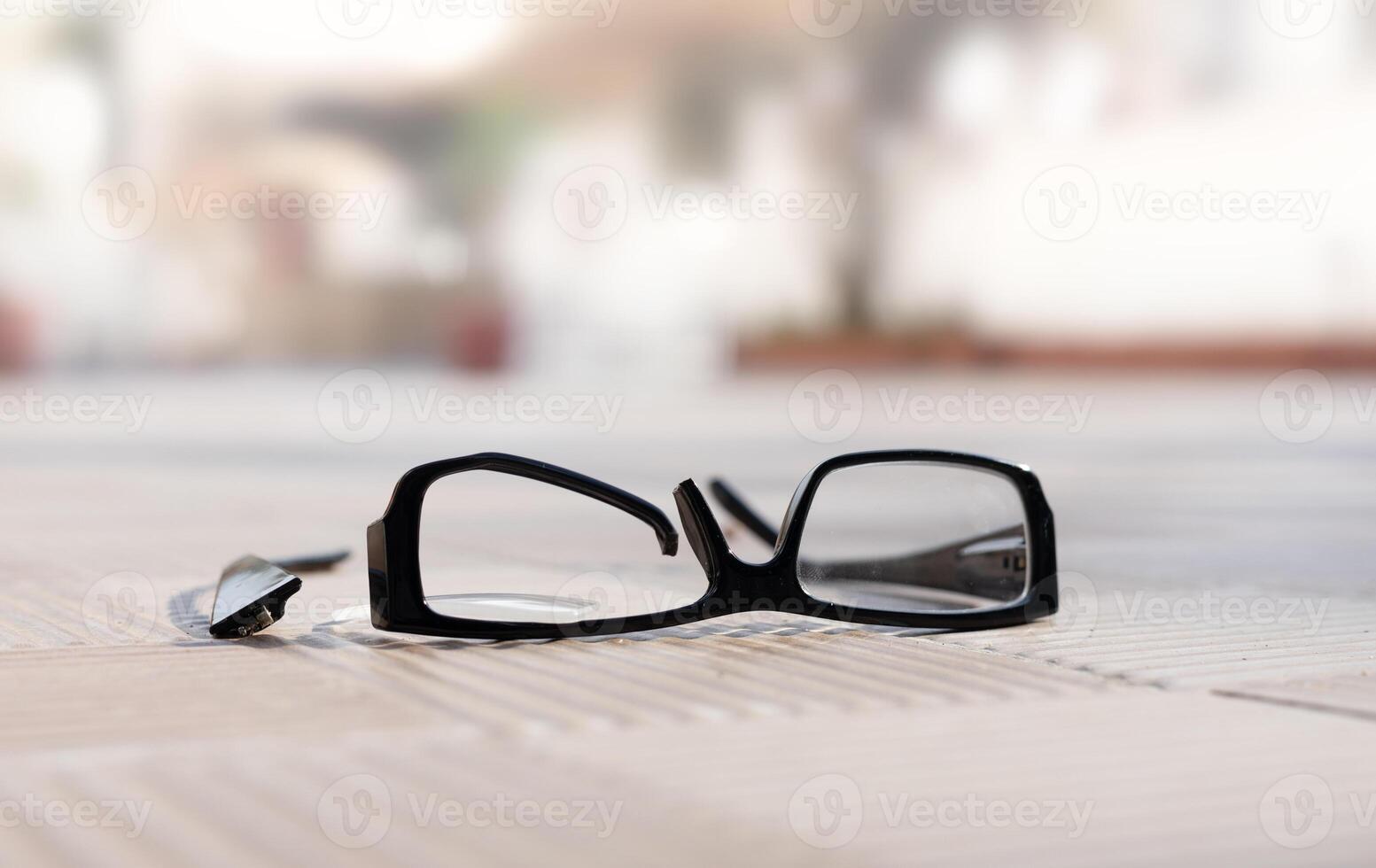 ein gebrochen Brille Rahmen Lügen auf ein Straße gerippt Fliese ein sonnig Tag. hoch Qualität Foto
