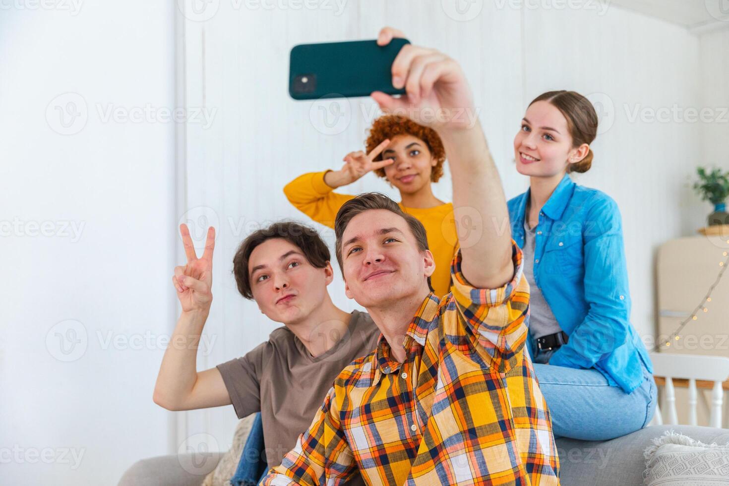 Prost funky Stimmung. glücklich Gruppe von freunde machen Selfie. Mann nehmen Foto von freunde beim Party. Gruppe von gemischtrassig jung Menschen nehmen Foto auf Telefon. jung Menschen genießen ihr Unternehmen Lächeln haben Spaß