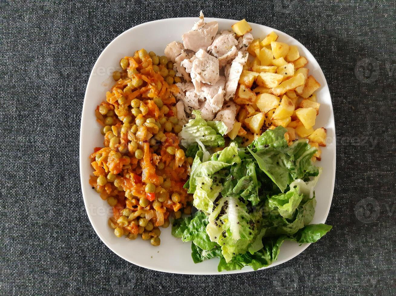 hausgemacht gegrillt Hähnchen mit Französisch Fritten, Grün Salat und Erbse Eintopf serviert auf ein Weiß Teller foto