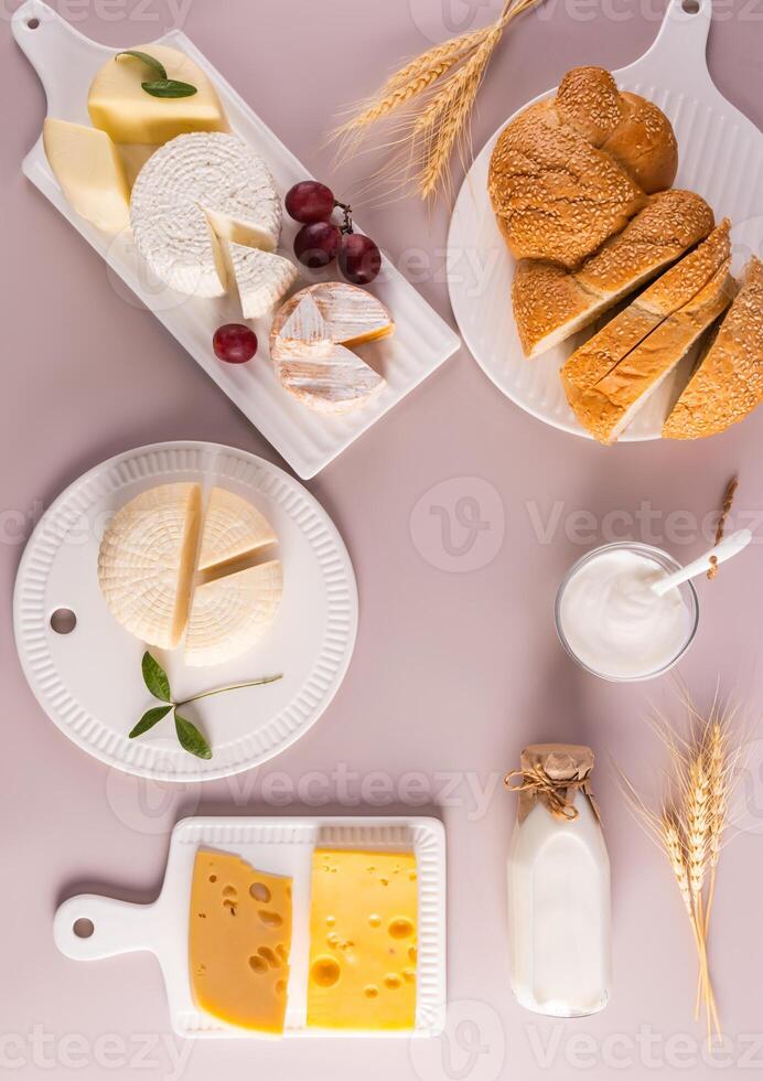 schön festlich Hintergrund zum das Urlaub von jüdisch Schawuot. viele von frisch Milch Leckereien auf Weiß Keramik Bretter. oben Vertikale Sicht. eben legen foto