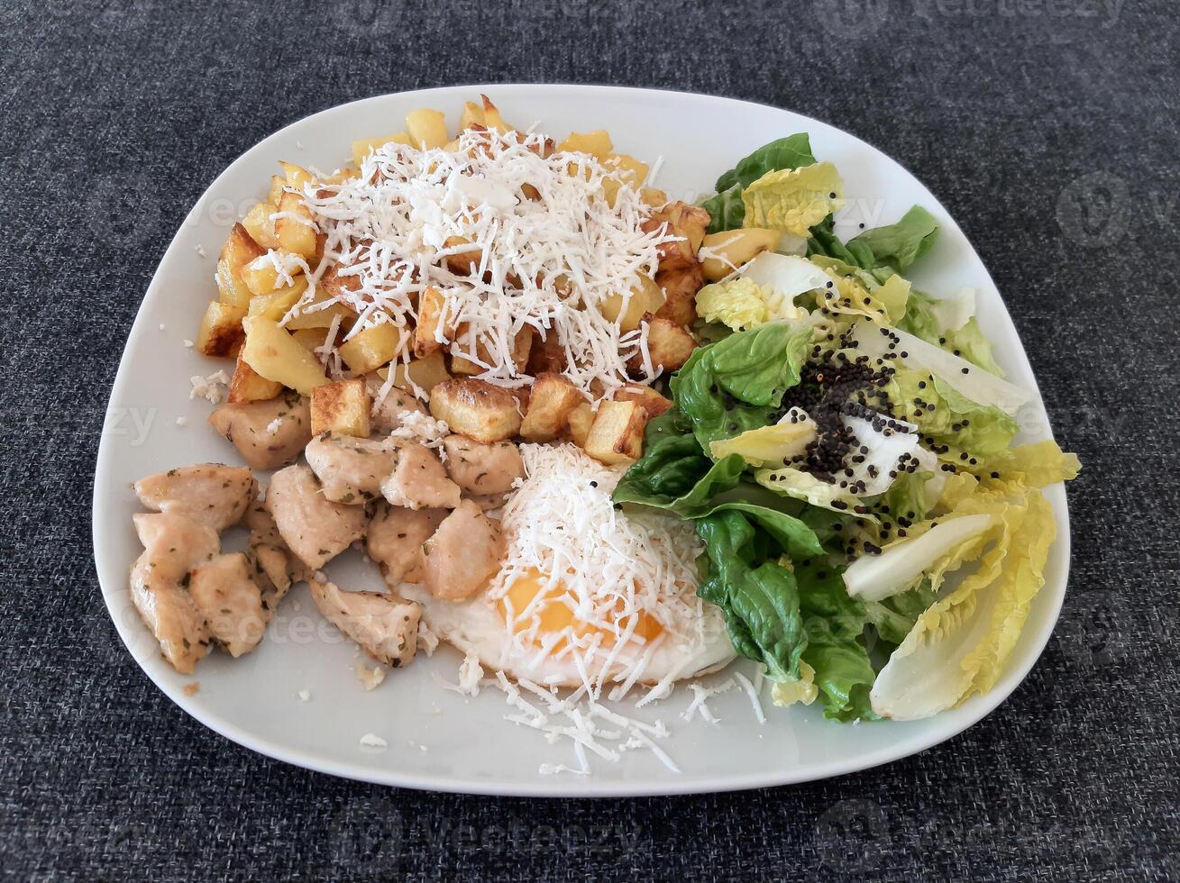 hausgemacht gegrillt Hähnchen mit Französisch Fritten, Käse und Grün Salat, serviert auf ein Weiß Teller foto