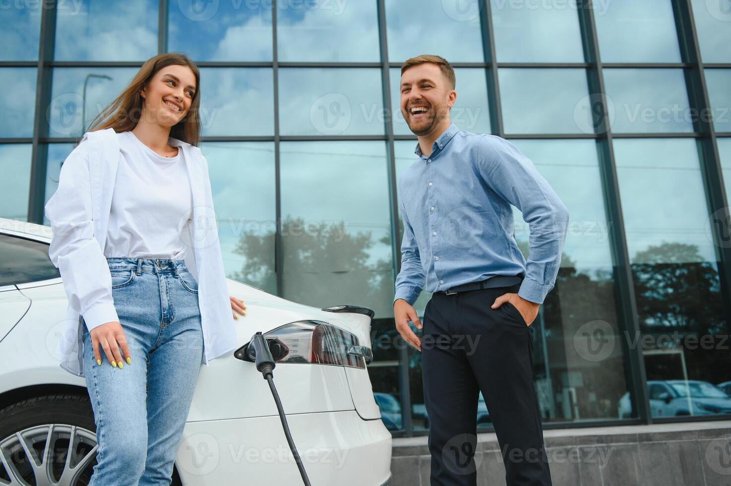 Paar auf das Laden Bahnhof zum elektrisch Fahrzeuge foto