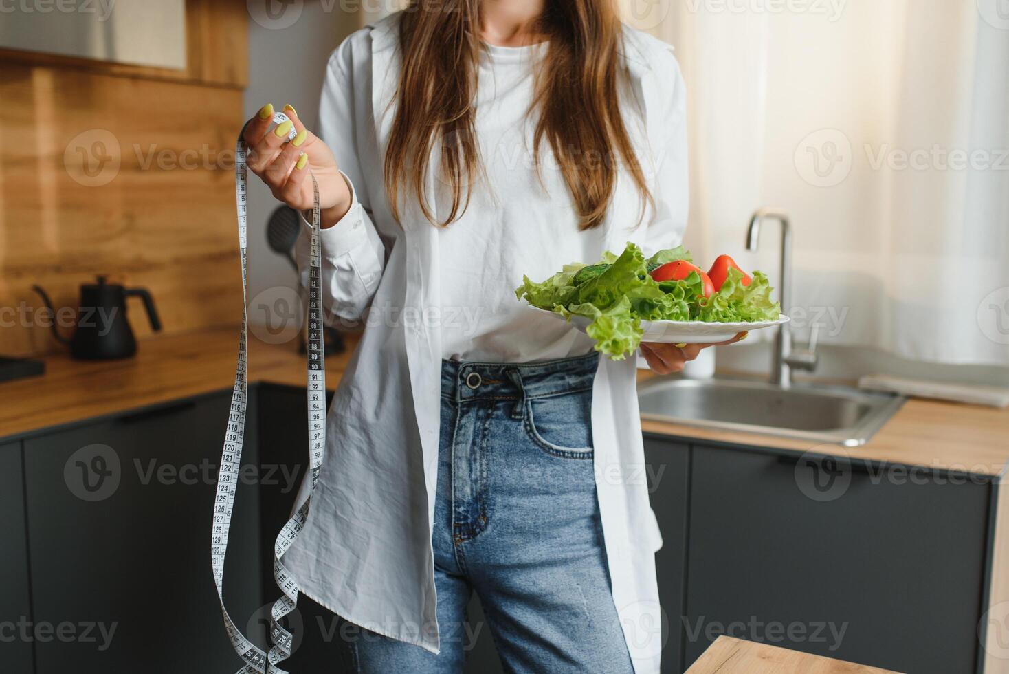 schön Frau Kochen gesund Essen im das Küche - - drinnen. jung Frau Kochen. gesund Essen - - Gemüse Salat. Diät. Diät Konzept. gesund Lebensstil. Kochen beim heim. bereiten Lebensmittel. foto