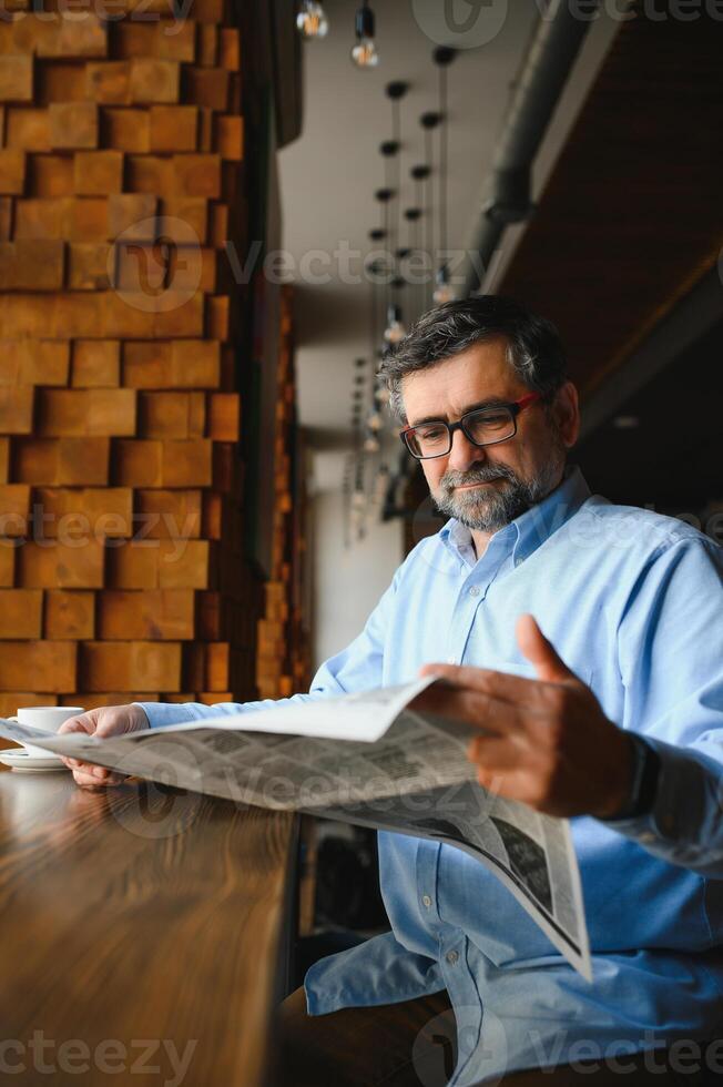 Zeitung im das Morgen. Senior Geschäftsmann beim seine Büro Reiten Zeitungen. foto