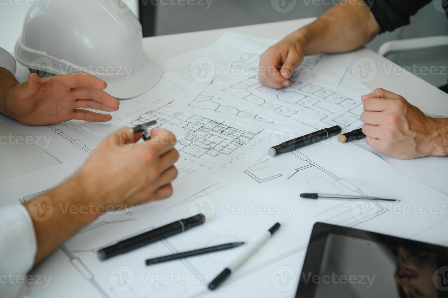 zwei Menschen sitzen im Vorderseite von Konstruktion planen und sich unterhalten Über das die Architektur foto