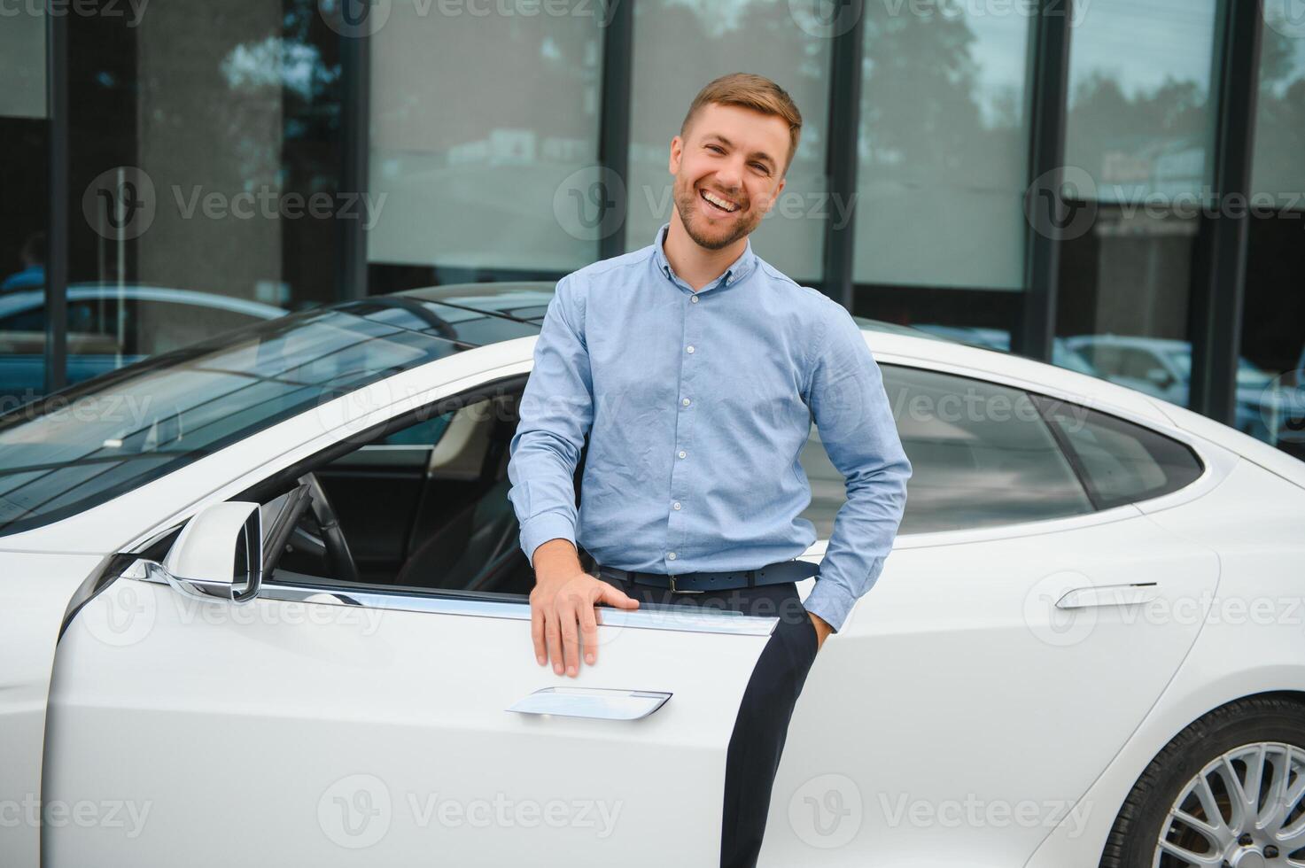 gut aussehend jung Geschäftsmann Stehen in der Nähe von seine Auto draußen. foto