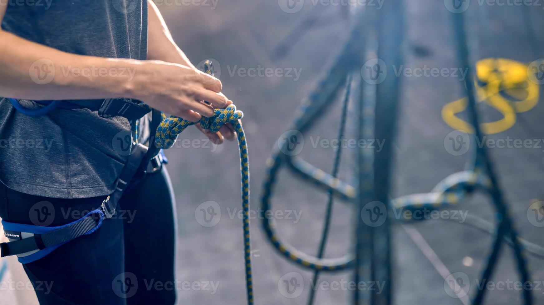 Frau binden das Klettern Seil mit zwei Hände foto