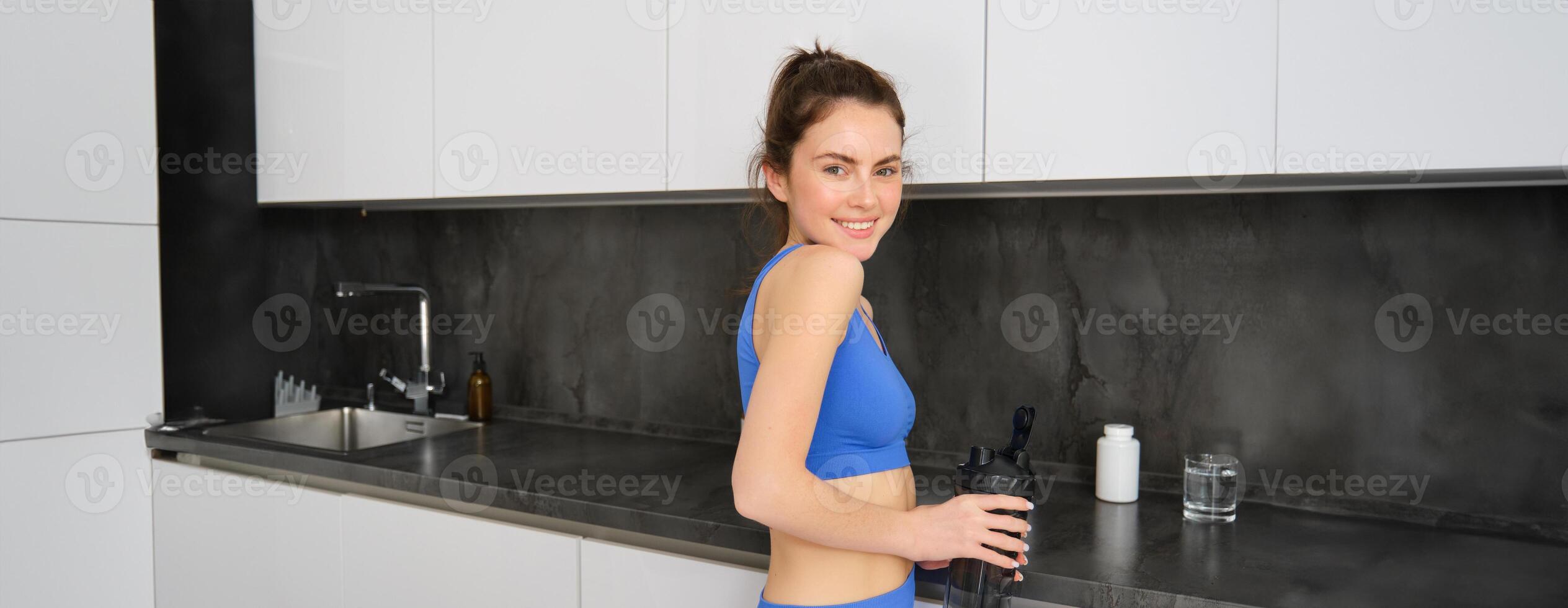 Bild von jung Fitness Frau, tragen Sportbekleidung, halten Wasser Flasche, Füllung oben von Zapfhahn zum trainieren Ausbildung Session foto