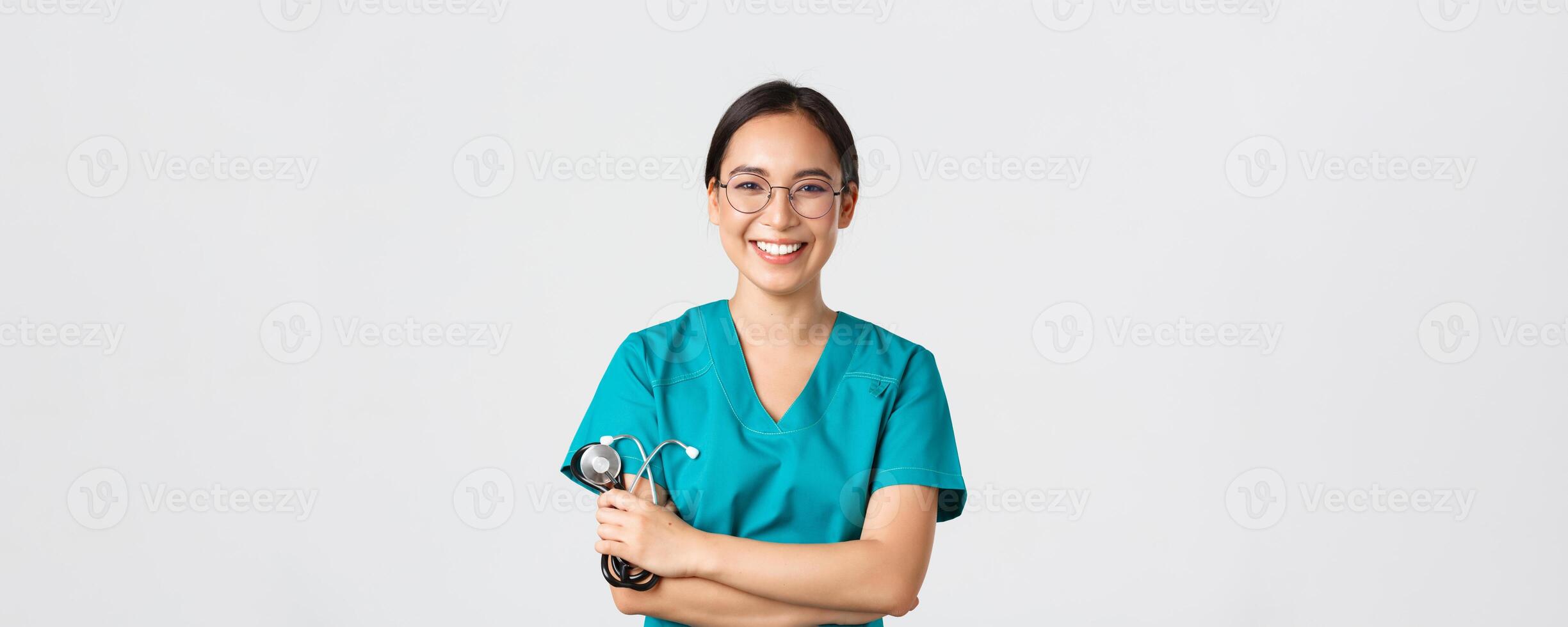 COVID-19, Coronavirus Krankheit, Gesundheitswesen Arbeitskräfte Konzept. zuversichtlich glücklich asiatisch weiblich Arzt, Arzt im Gläser, Kreuz Waffen Truhe und lächelnd, halten Stethoskop zum Untersuchung foto