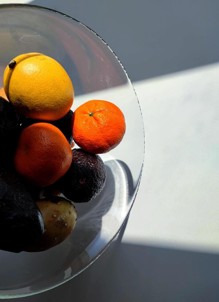 tropisch Früchte im ein Glas Vase. Zitrone, Avocado, Mandarine und andere foto