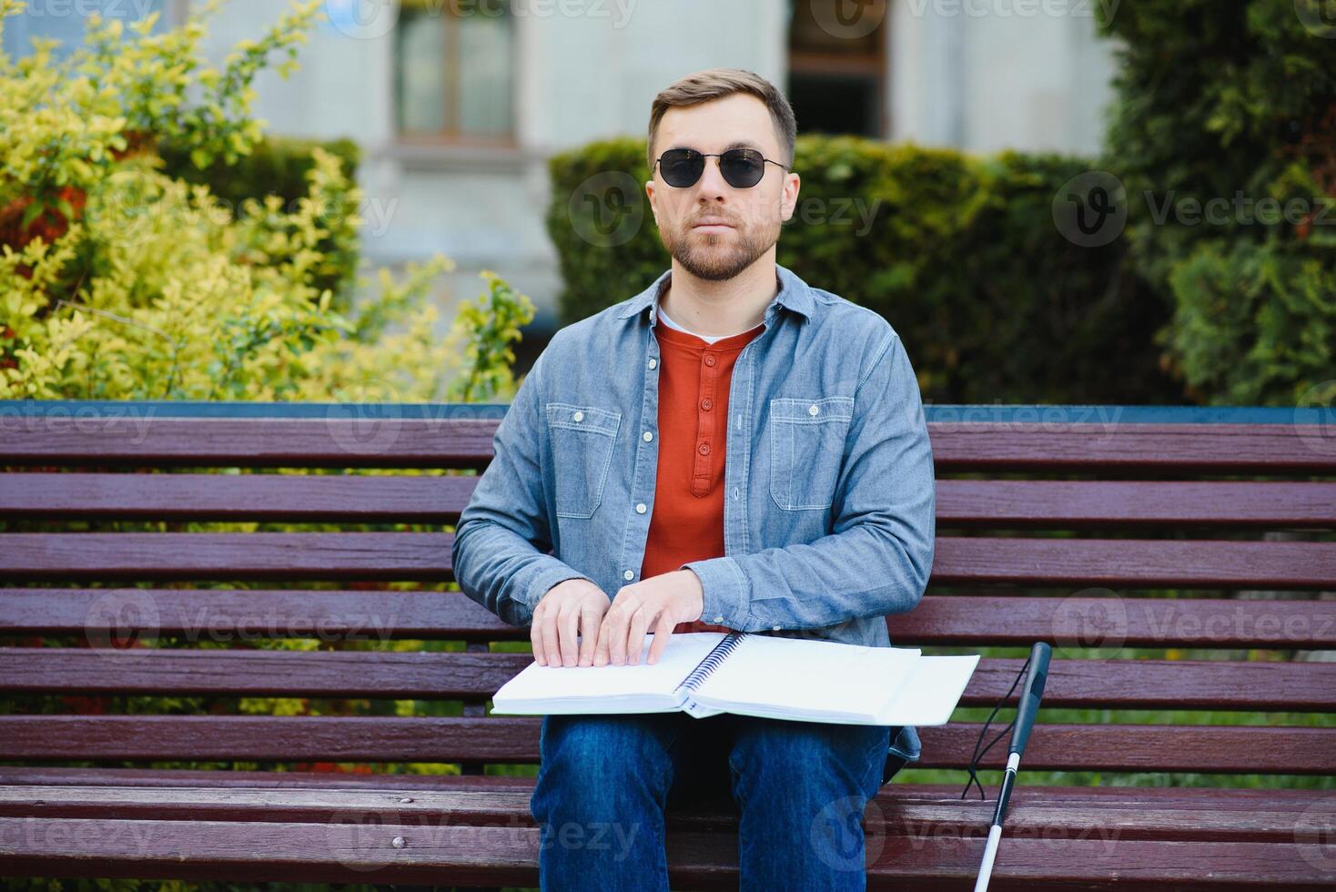 blind Mann lesen Buch auf Bank im Park foto