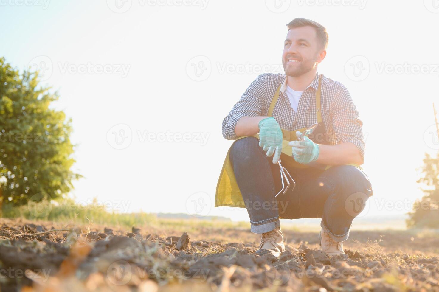 Landwirtschaft. Farmer mit ein Schaufel im das Feld. Geschäft Boden Sonne natürlich Produkte Ernte foto