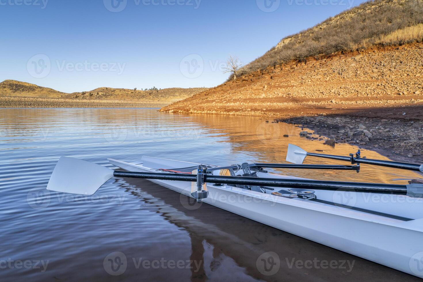 Küsten Rudern Schale auf ein Ufer von Pferdezahn Reservoir im fallen oder Winter Landschaft mit ein niedrig Wasser eben. foto
