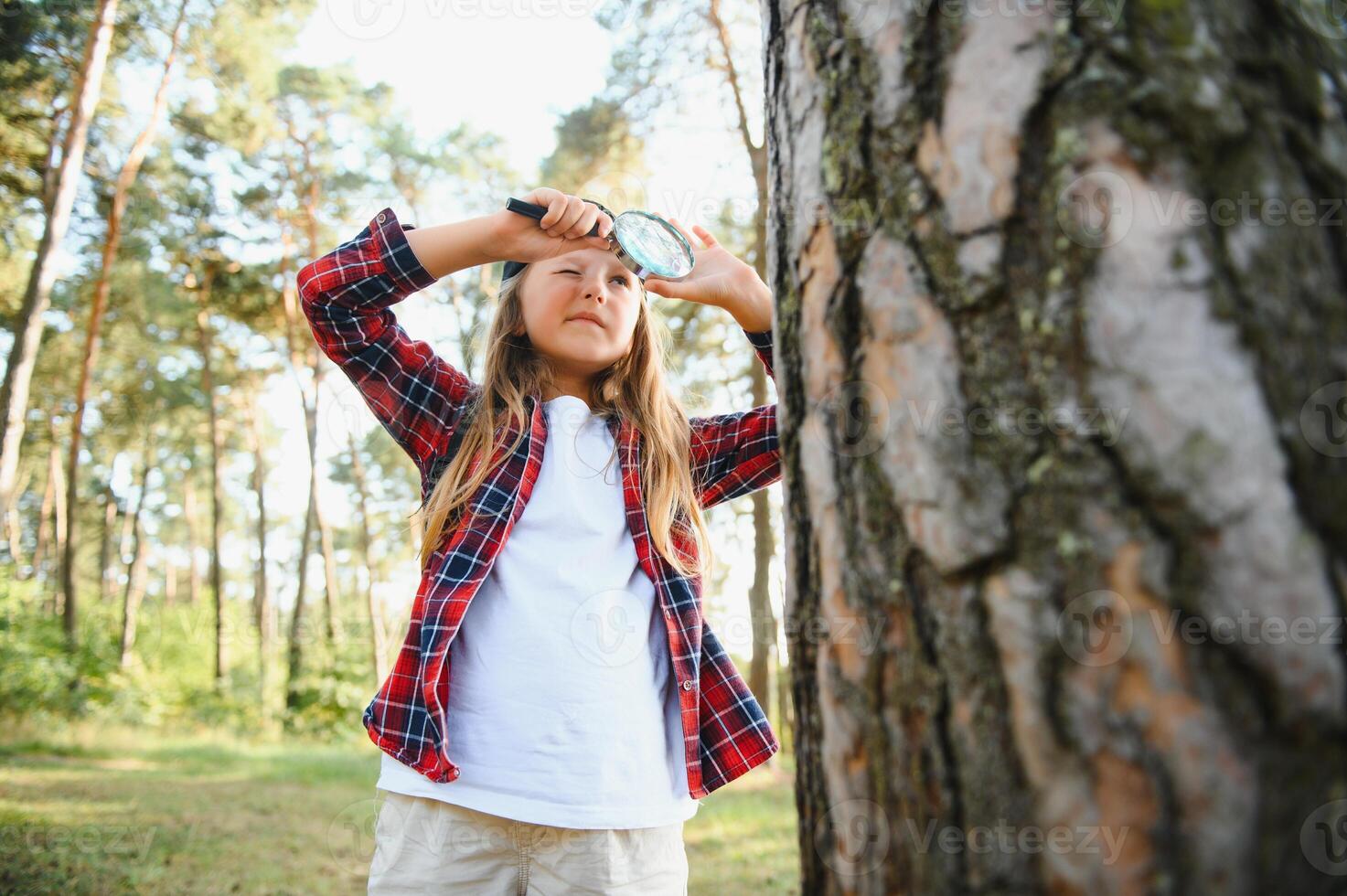 Bild von süß Kind mit Vergrößerung Glas erkunden das Natur draußen. bezaubernd wenig Mädchen spielen im das Wald mit Vergrößerung Glas. neugierig Kind suchen durch Lupe auf ein sonnig Tag im Park. foto