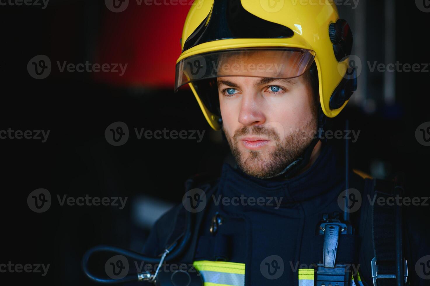 Feuerwehrmann Feuerwehrmann im Aktion Stehen in der Nähe von ein Feuerwehrauto. Notfall Sicherheit. Schutz, Rettung von Achtung. foto