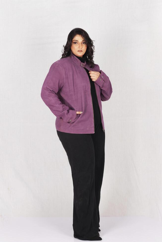 ein Frau im ein lila Jacke und schwarz Hose foto