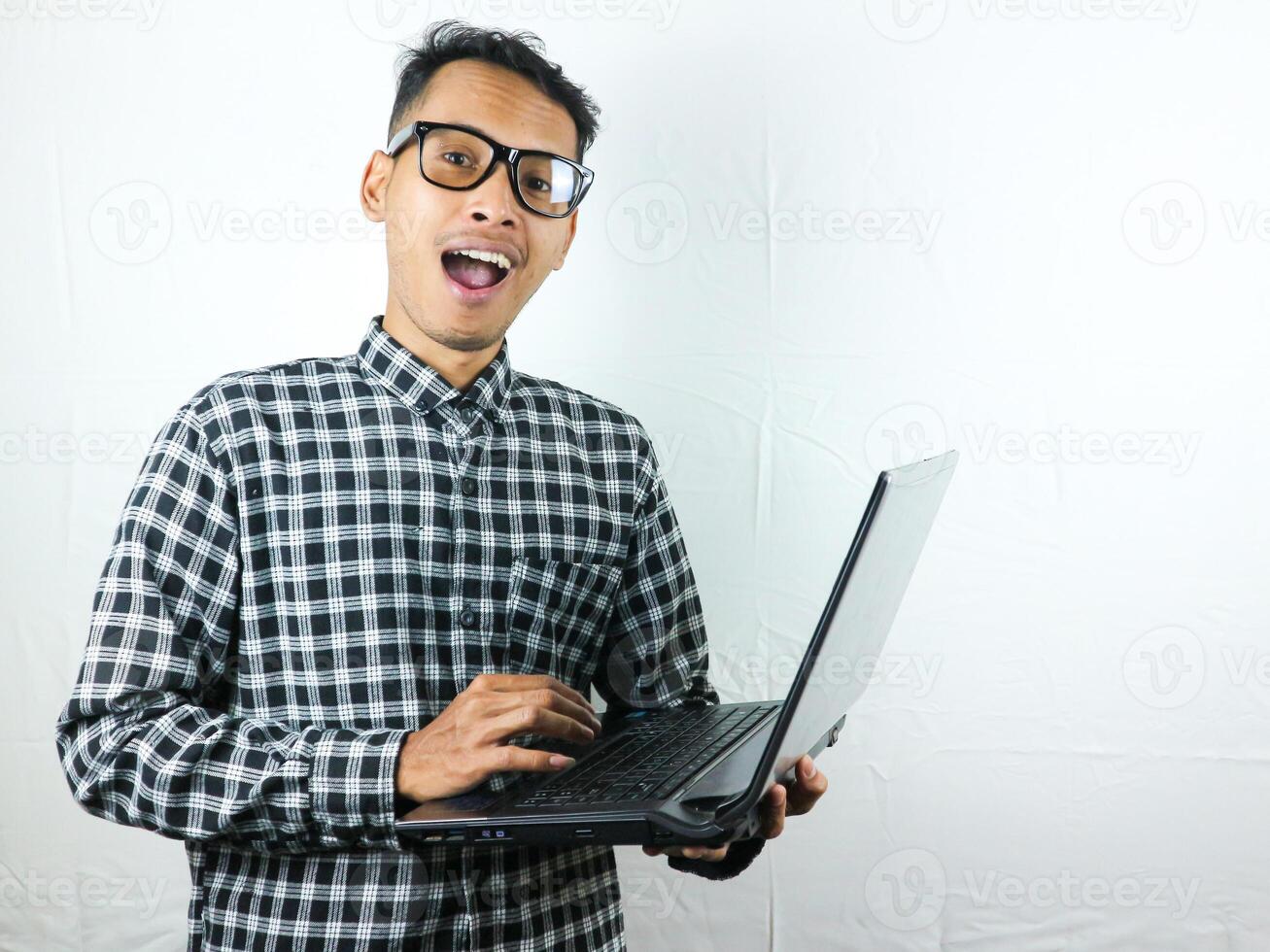 Porträt von ein asiatisch Mann halten ein Laptop mit ein lächelnd Gesicht Ausdruck. Werbung Konzept. foto