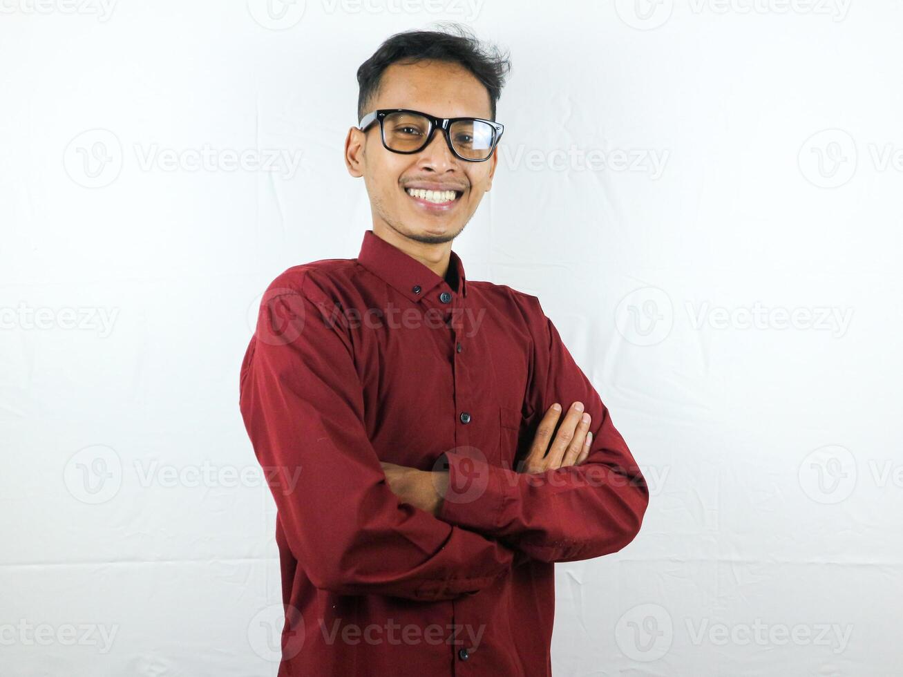 lächelnd gut aussehend asiatisch Mann im beiläufig rot Hemd mit Arm gekreuzt foto