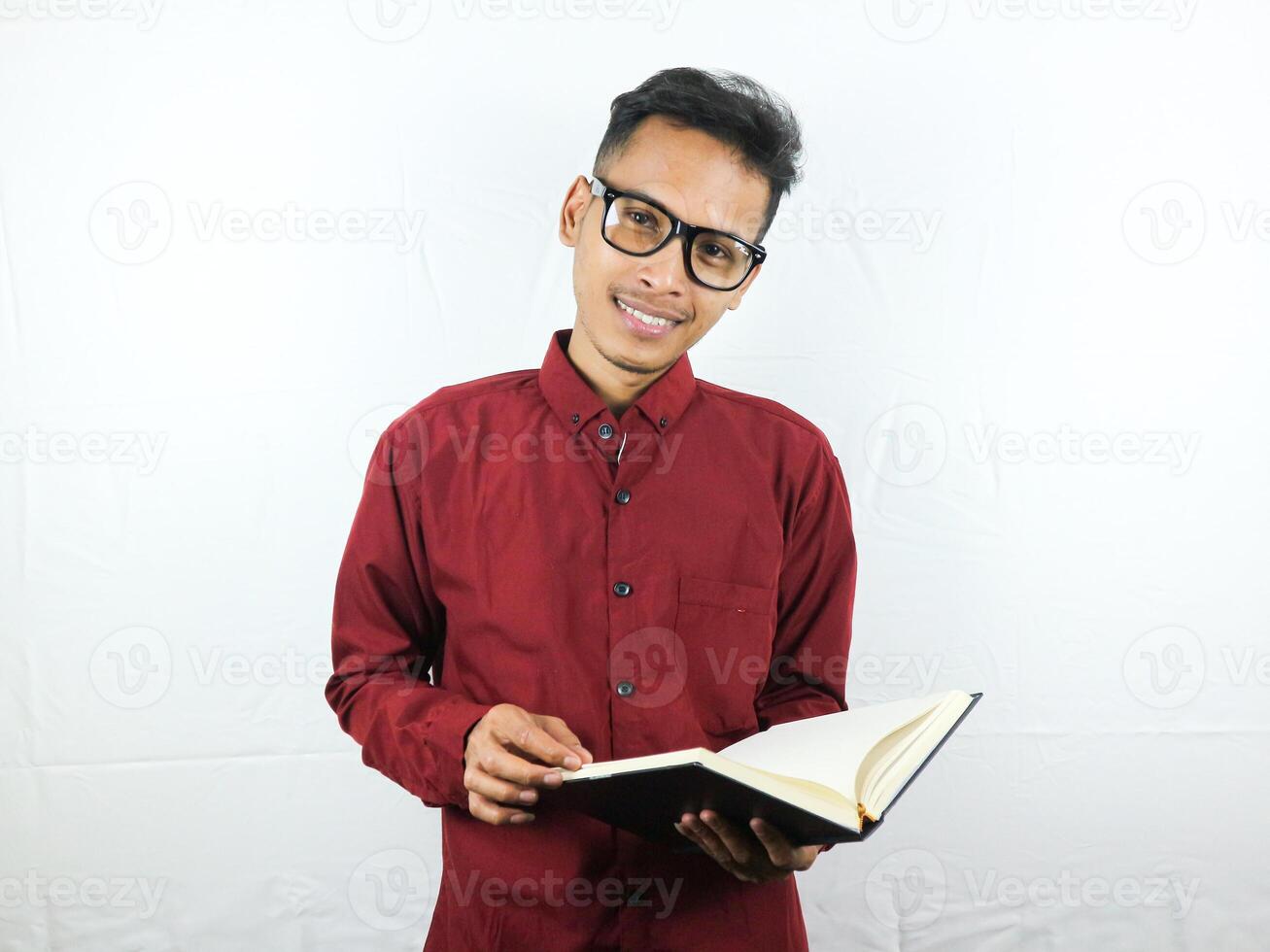 gut aussehend asiatisch Geschäft Mann lächelnd und halten und lesen Buch im Hand foto