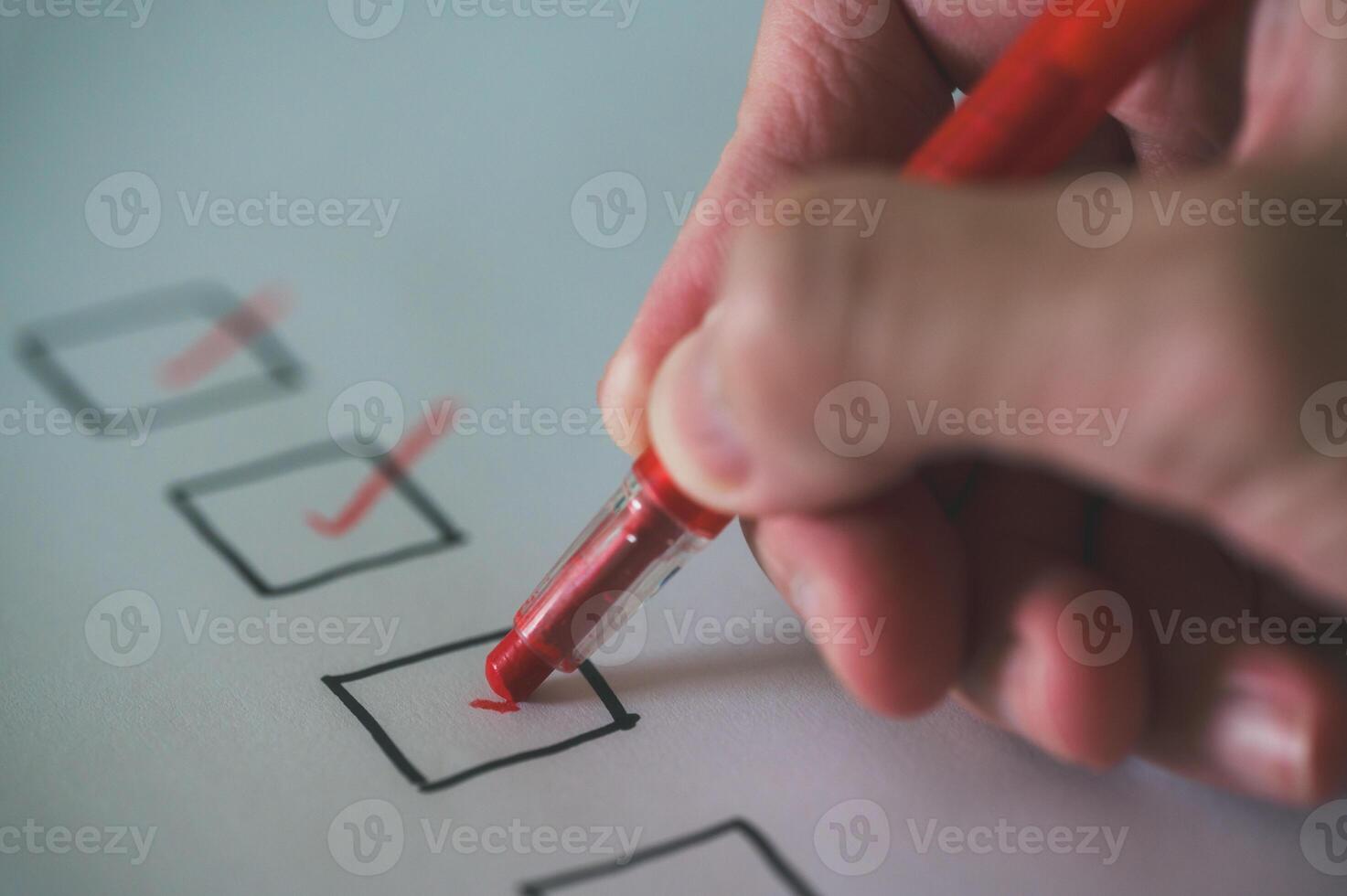 schließen oben und selektiv Fokus Hand mit Stift zu Herstellung Tick Kennzeichen auf prüfen aufführen Box prüfen aufführen und Marker foto