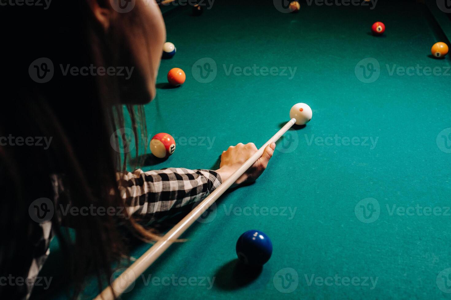 ein Mädchen im ein Hut im ein Billard- Verein mit ein Stichwort im ihr Hände Treffer ein Ball.spielen Billard foto