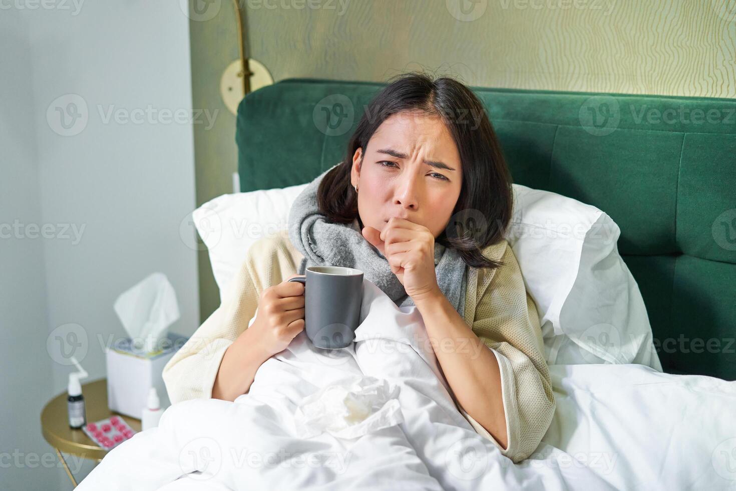 Porträt von Liegen asiatisch Mädchen im Bett, Gefühl krank, fangen kalt und bleiben beim heim, suchen ungesund, Trinken heiß Tee foto