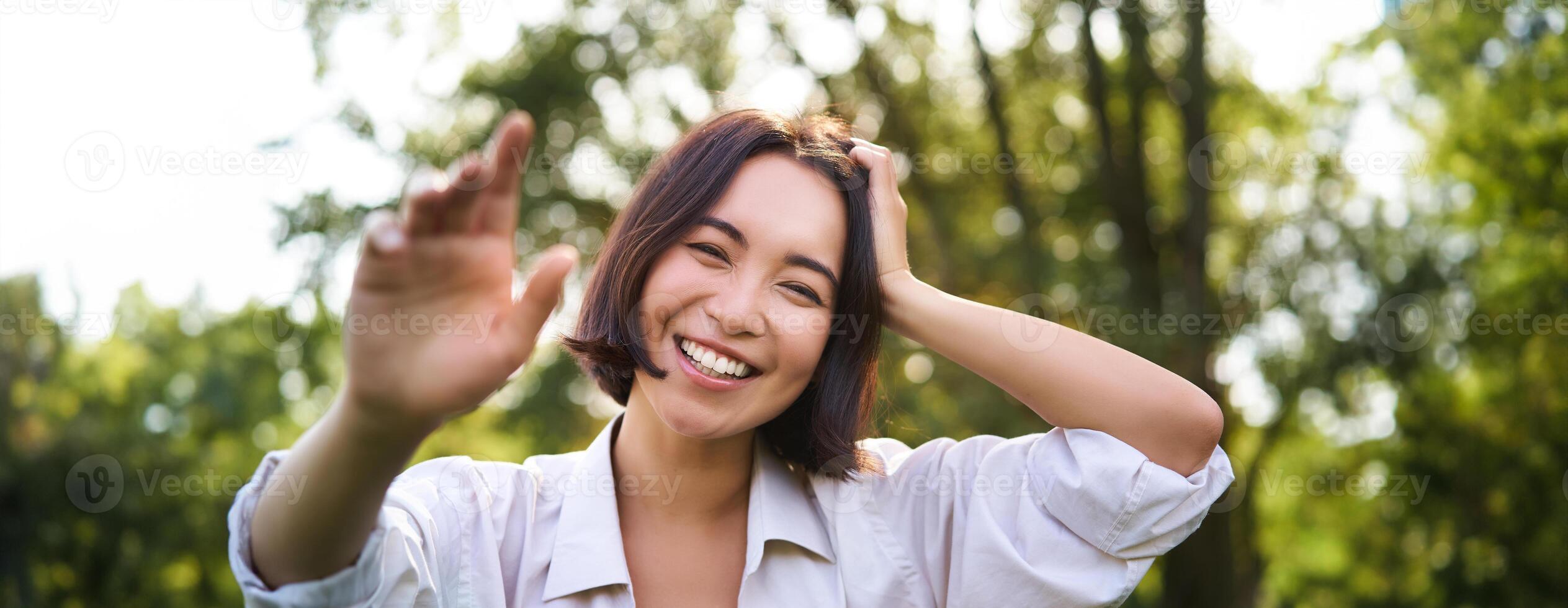 Menschen und Emotionen Konzept. glücklich asiatisch Frau Lachen und lächelnd, posieren auf Sommer- Tag im Park foto