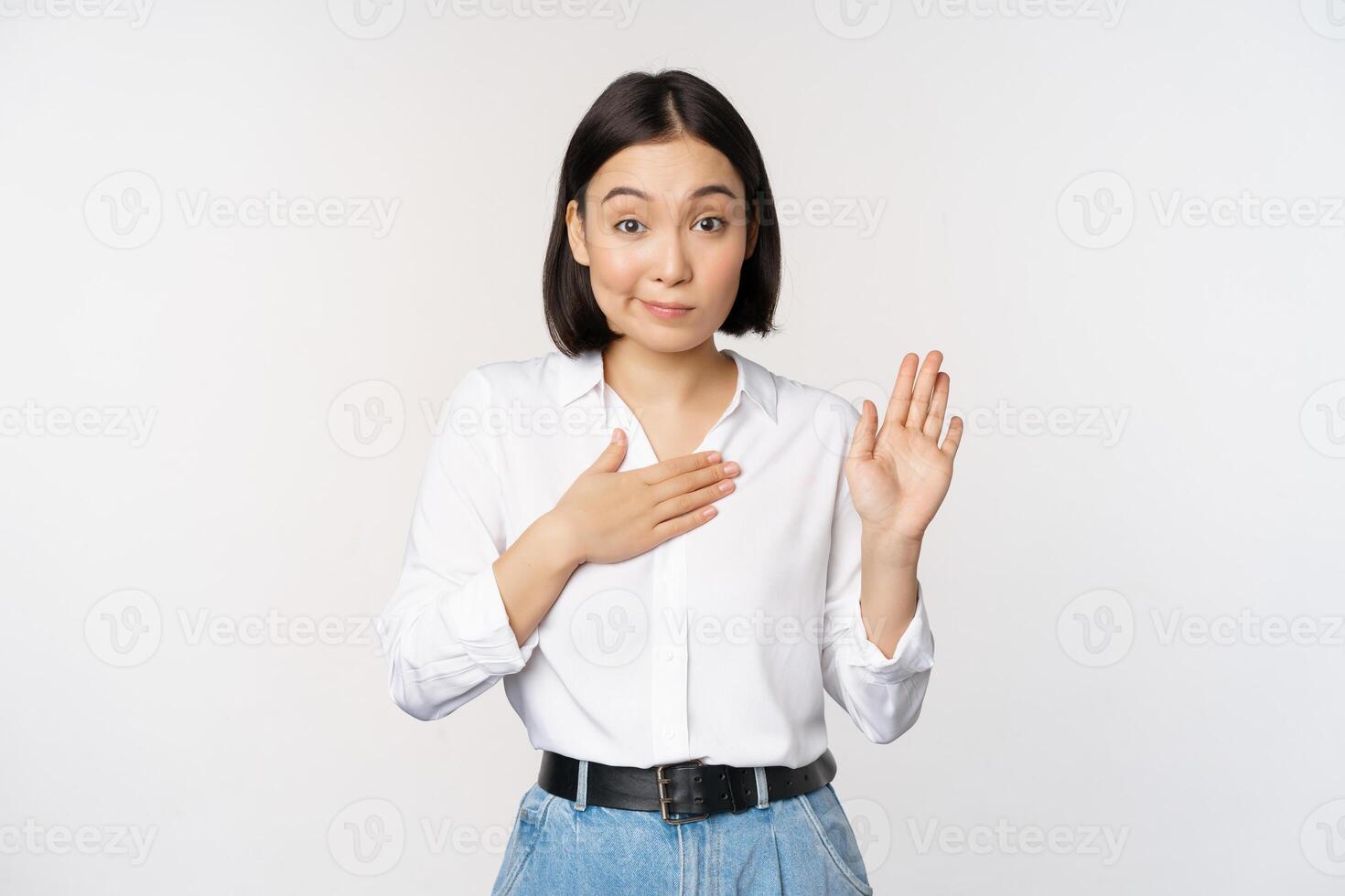 Bild von süß jung weiblich Büro Arbeiter, asiatisch Mädchen Schüler erziehen Hand oben und stellen Palme auf Brust, Name Sie selber, einführen, Herstellung versprechen, Stehen Über Weiß Hintergrund foto