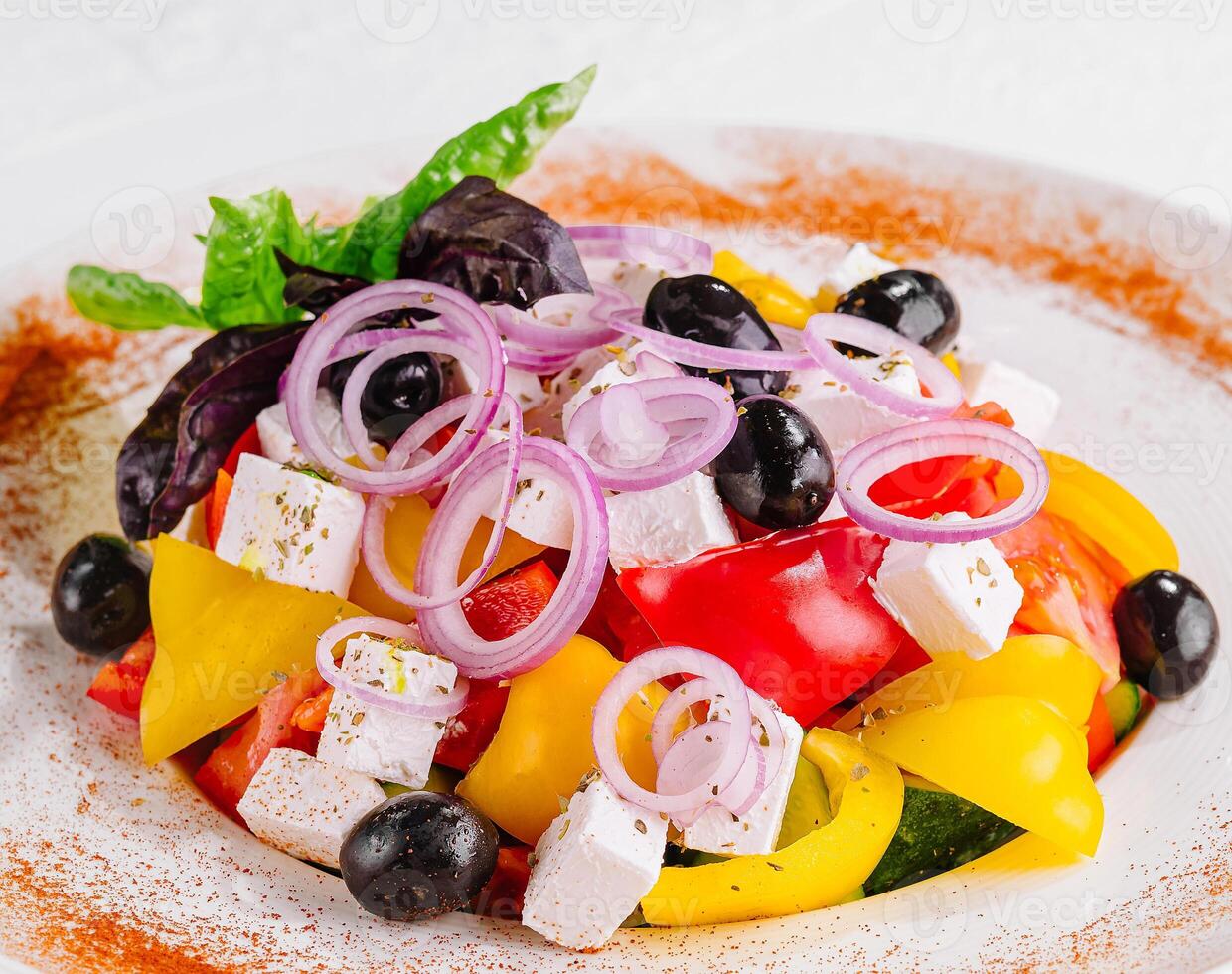 frisch hausgemacht griechisch Salat mit Basilikum Blätter auf ein Teller foto