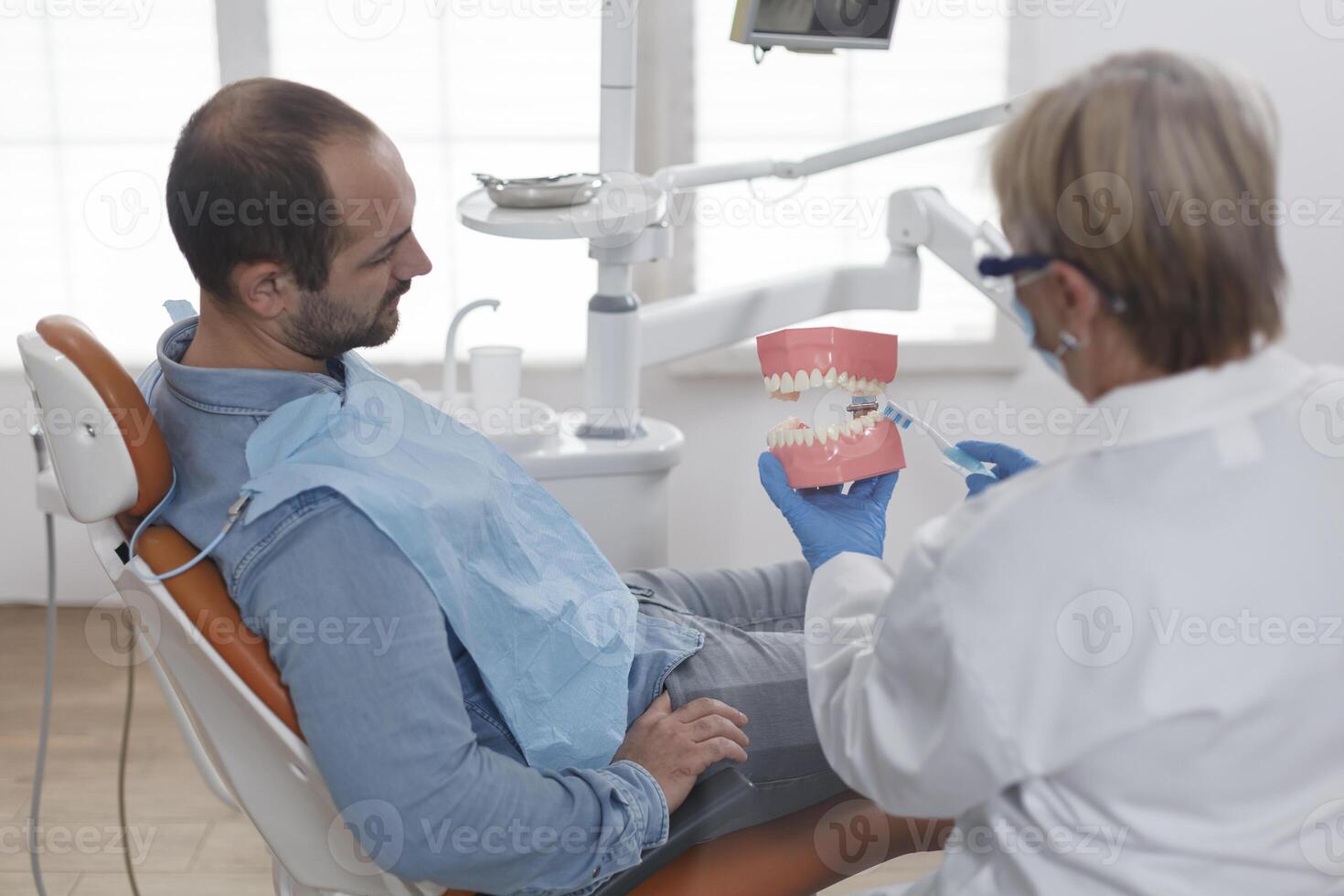 dspezialist Kieferorthopäde zeigen Keramik Kiefer Modell- zu geduldig mit Zahnschmerzen diskutieren Träger Behandlung während Stomatologie Beratung im Zahnheilkunde Büro Zimmer. Arzt Frau erklären Oral Hygiene foto