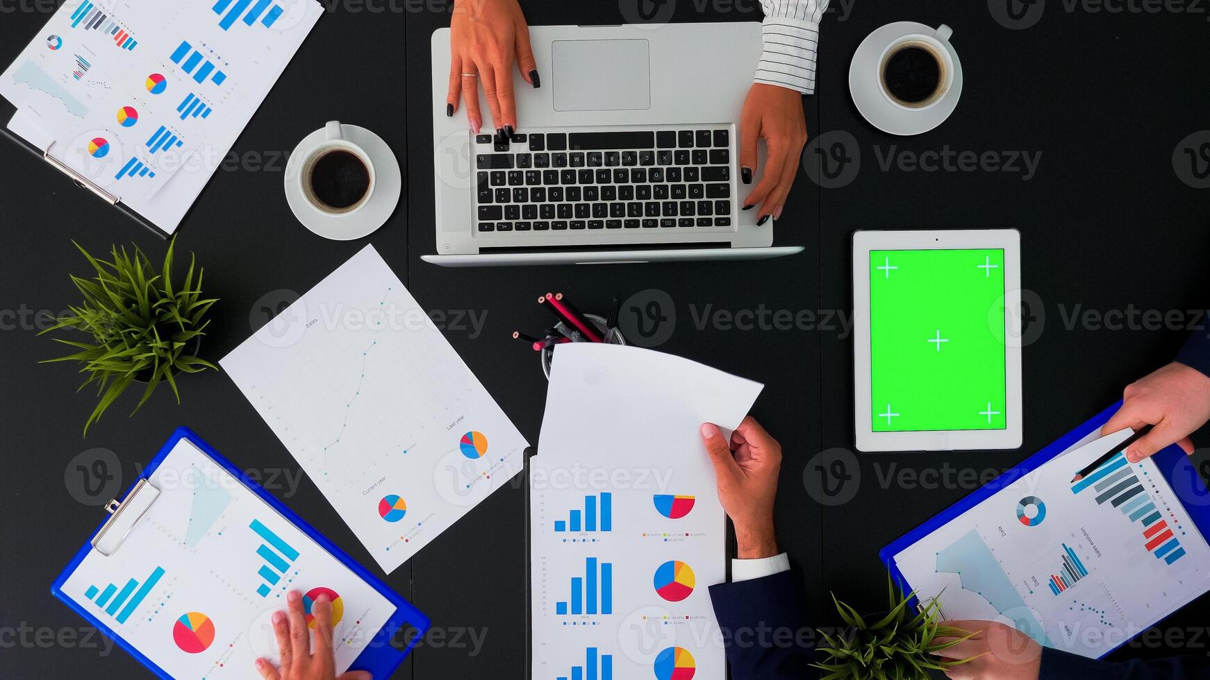 hoch Winkel Aussicht von Geschäft Menschen im Konferenz Zimmer mit Grün Bildschirm Chroma Schlüssel Tablette auf Büro Tisch. Mitarbeiter haben Treffen Analysieren finanziell Statistiken Grafiken Planung Nächster Projekt. foto