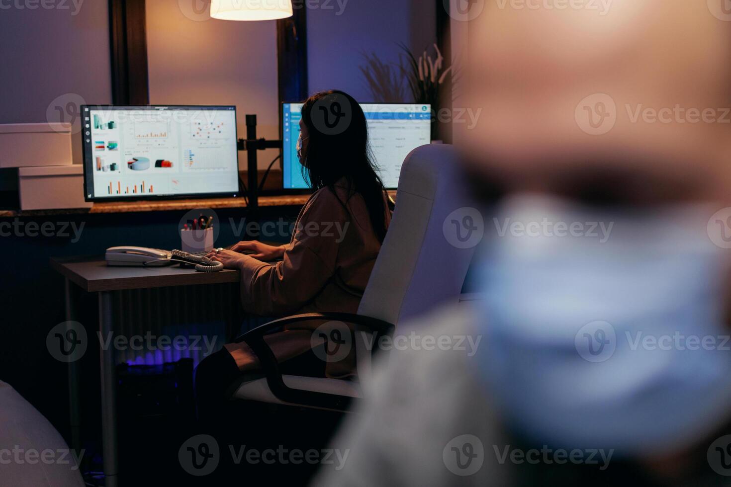 Geschäftsfrau trägt chirurgisch Maske im Büro mit Kollege. betont Mann im Konzern Arbeiten schwer zu Fertig ein Projekt tragen Gesicht Maske wie Sicherheit Vorsicht fällig zu Coronavirus Pandemie. foto