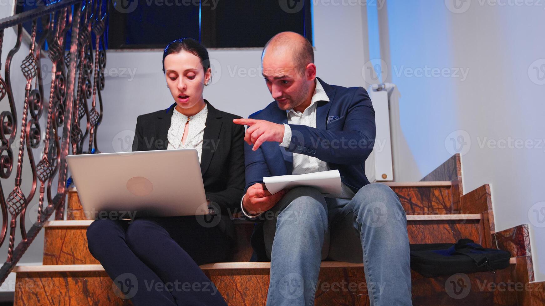 überarbeitet müde Geschäftsmann tun im Laufe der Zeit Sitzung auf Treppe Portion Mitarbeiter mit schwierig Frist mit Tablette und Laptop. Kollegen Unternehmer Arbeiten spät zusammen beim korporativ Arbeit. foto