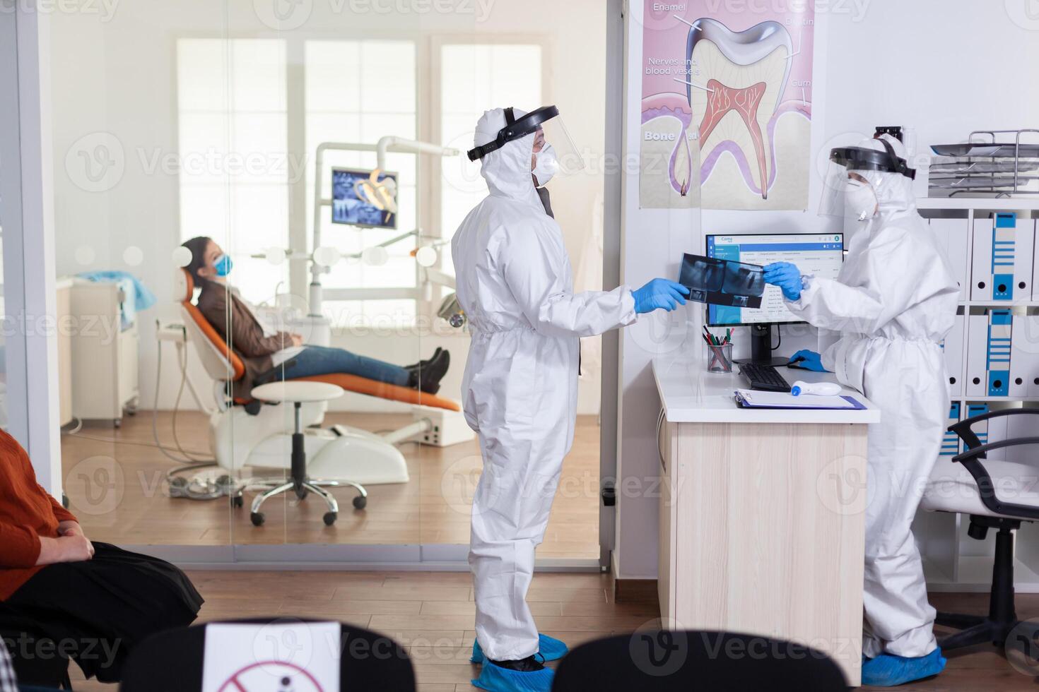 Dental Rezeptionist gekleidet im Overall Gesicht shiled geben Arzt geduldig Röntgen behalten Sozial Distanzierung während covid19 Virus Pandemie. Frau warten Arzt Diagnose. foto