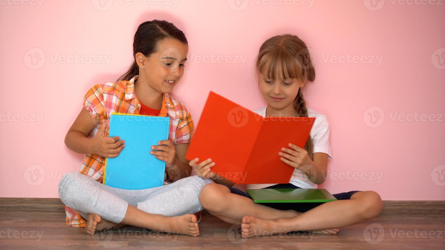 schön wenig Mädchen sind lesen ein Buch. das Konzept von Bildung. isoliert auf Rosa Hintergrund foto