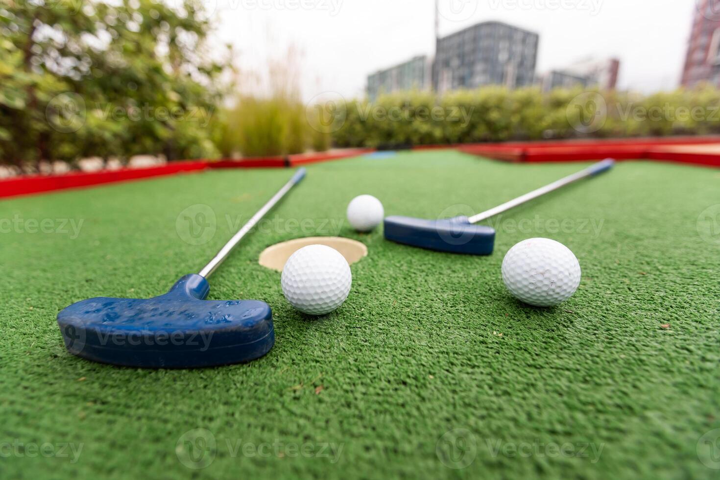 ein Verein bereitet vor zu schlagen ein Ball während ein Mini Golf Spiel foto