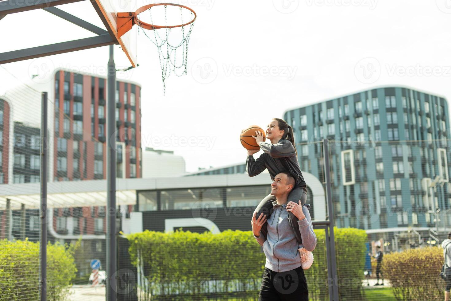 glücklich Vater und Teen Tochter draußen beim Basketball Gericht. foto