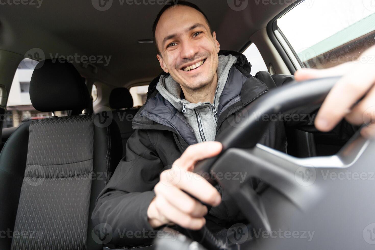 meine Baby. Schuss von ein glücklich Mann Sitzung im seine Auto berühren das Instrumententafel sanft lächelnd fröhlich foto